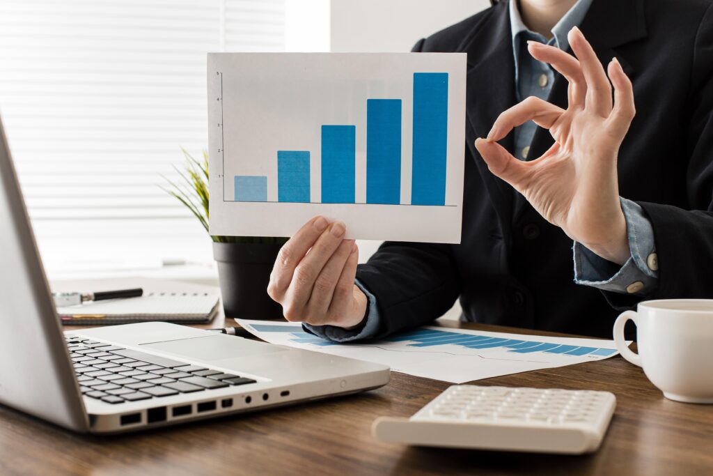 empresario-fazendo-sinal-de-ok-enquanto-segura-o-grafico-de-crescimento